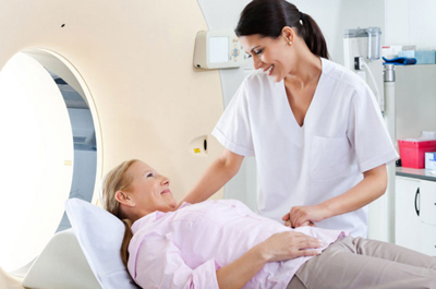 Patient preparing for a MRI scan with the help of a technologist.